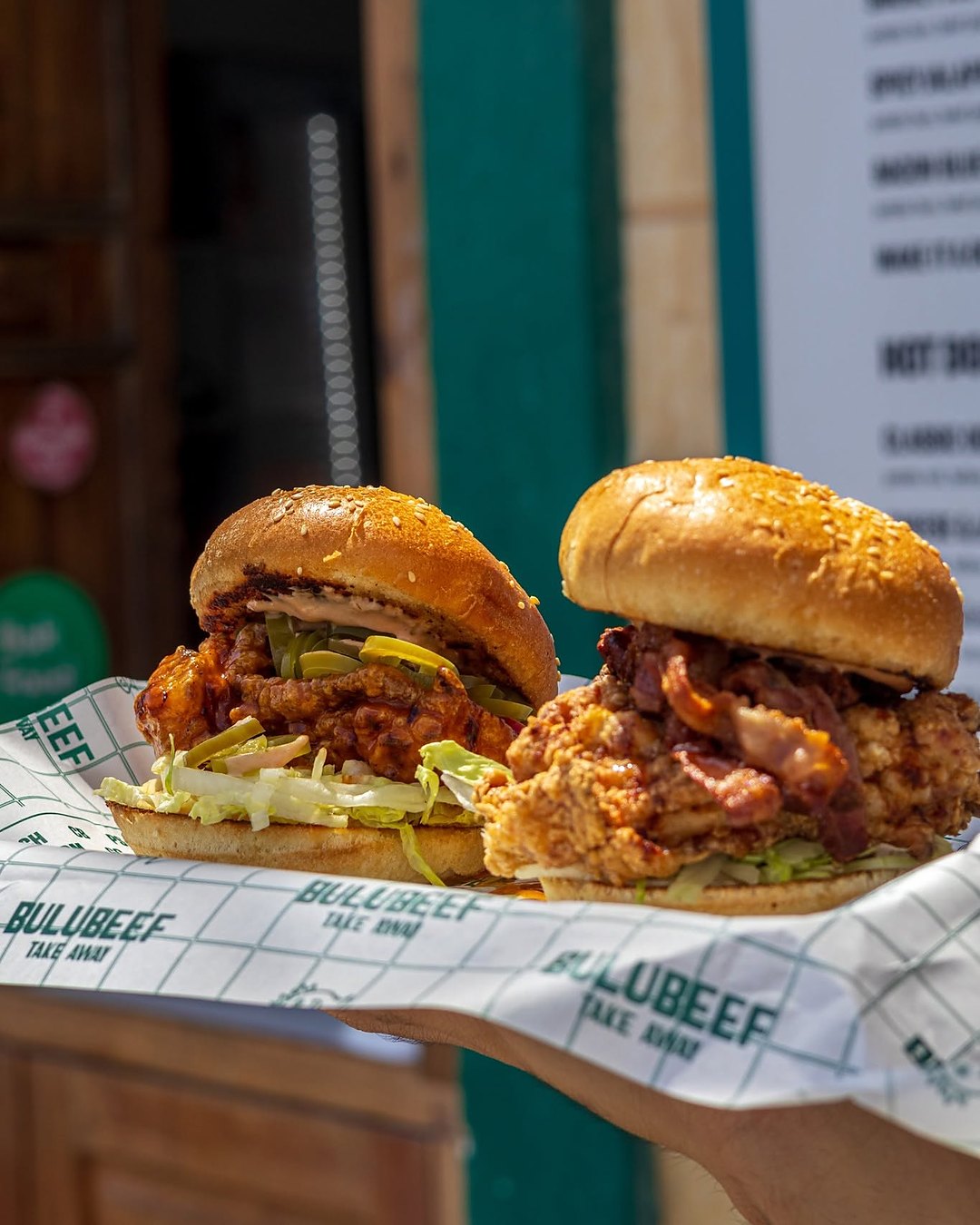 Two Bulubeef buttermilk fried chicken burgers on the branded paper